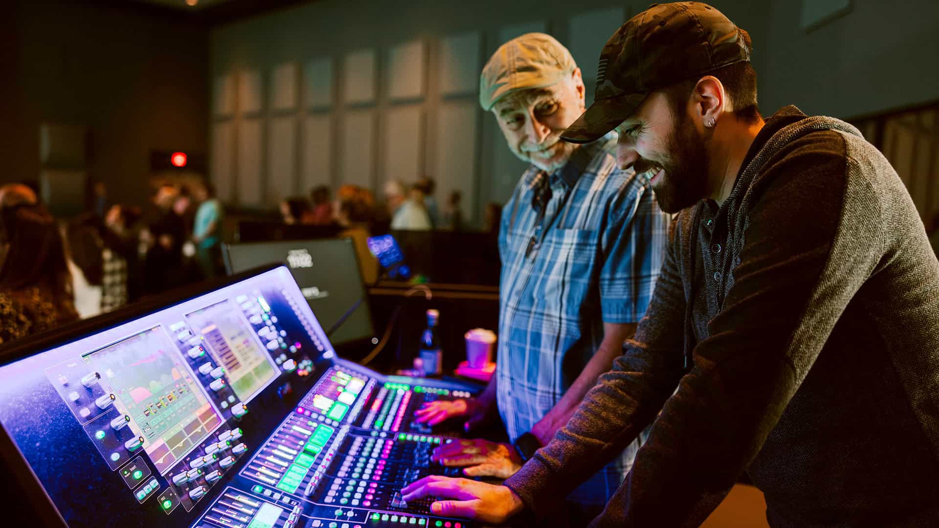 A male volunteer operating the production board at a North Way worship service.