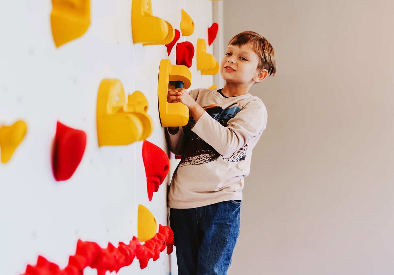 Child climbing the wall at North Way Sewickley Valley Autism Ministy