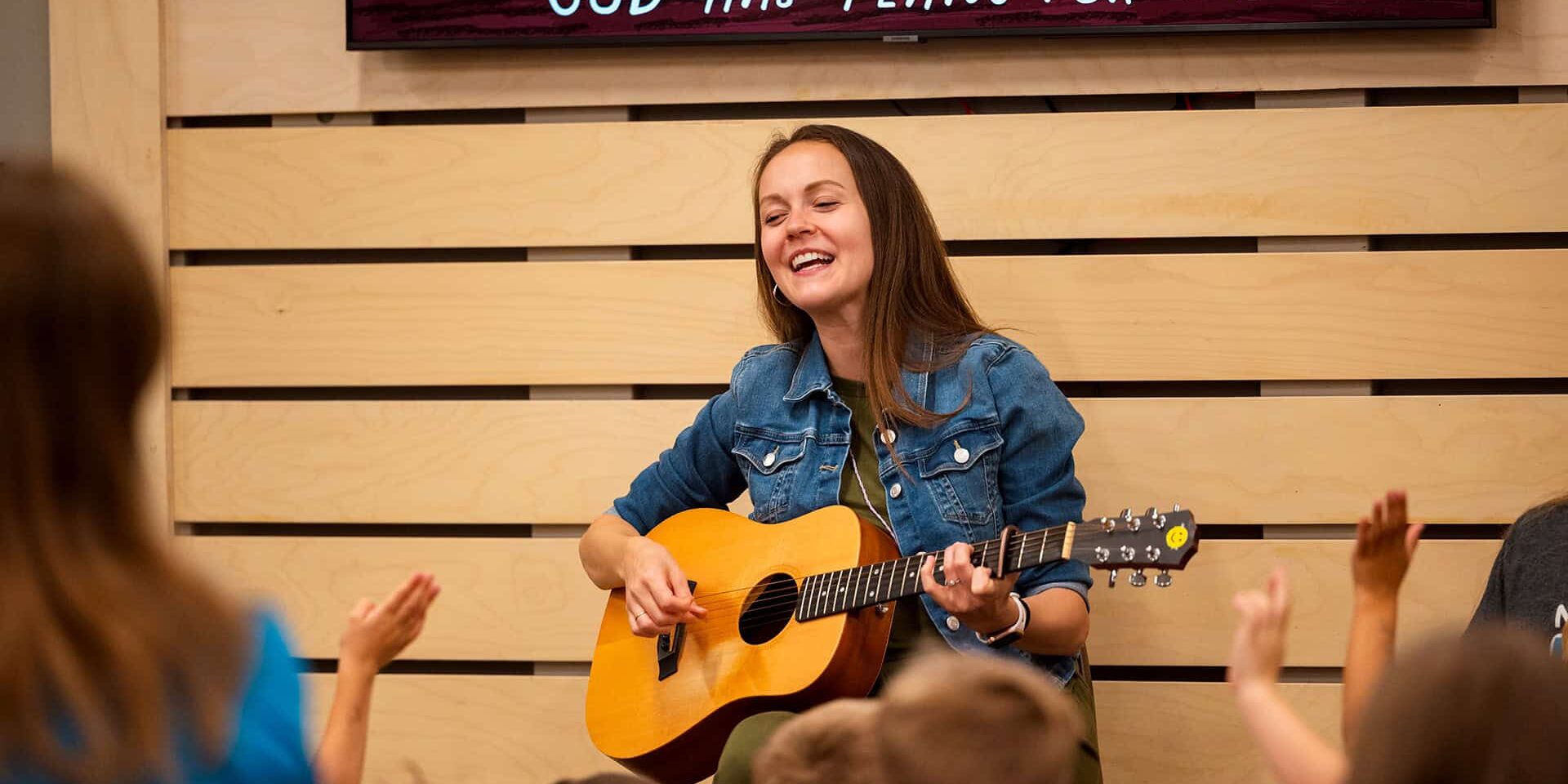 A North Way Kids Ministry volunteer playing the guitar at our Wexford PA church campus.