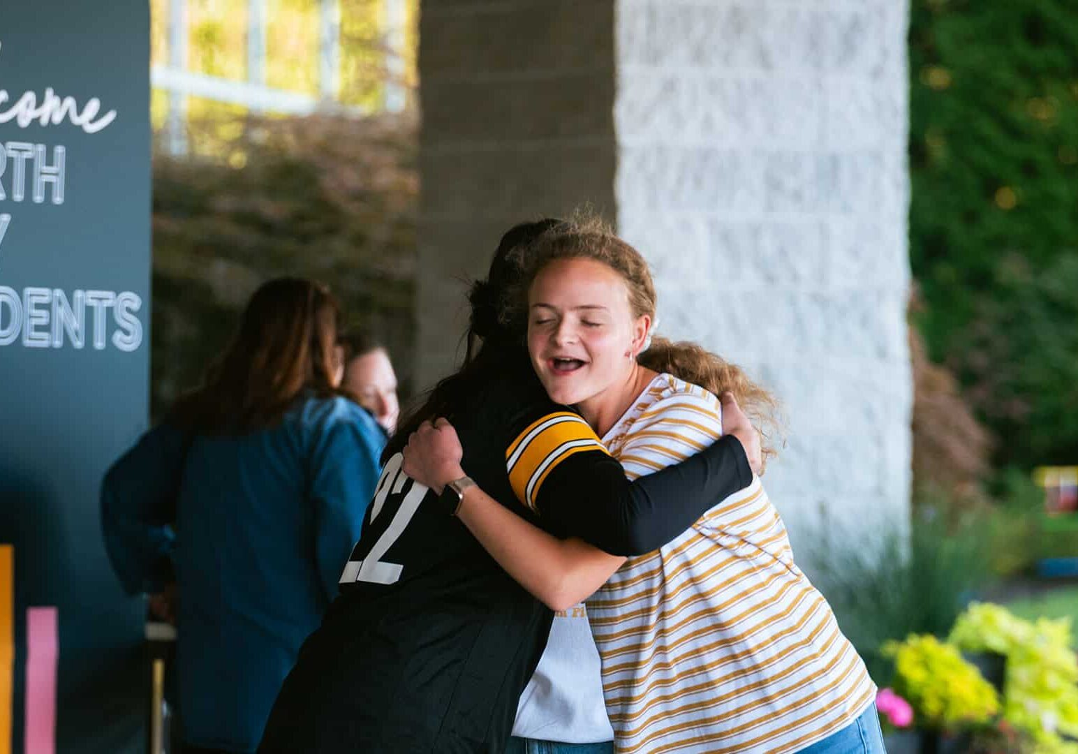 Two girl students hugging each other at a North Way Christian Community Fall Kickoff event